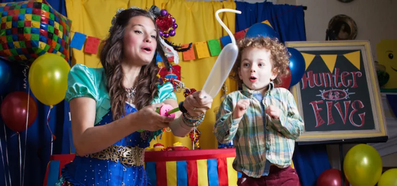 A child delighted by a freshly twisted balloon animal.