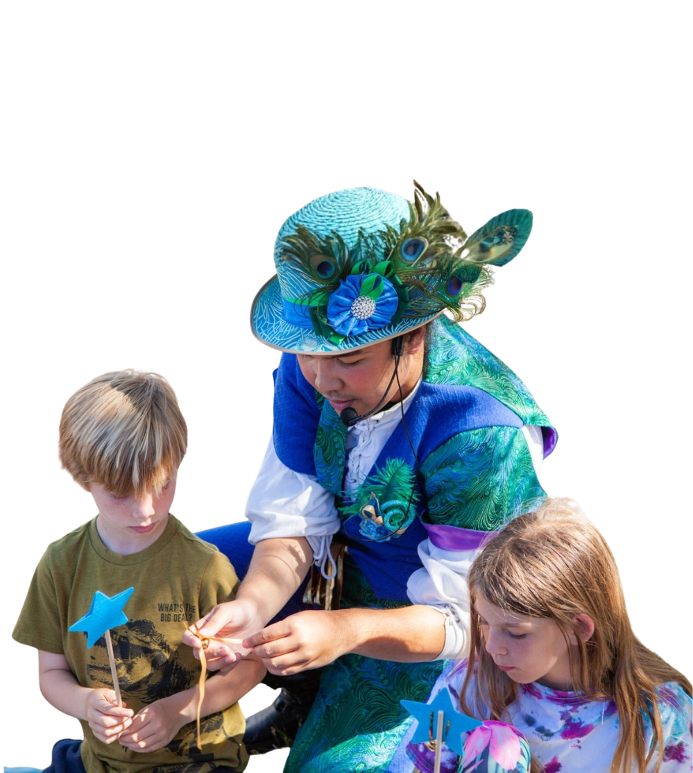 A Happily Ever Laughter craft leader in a blue jester costume holding a magic wand craft.
