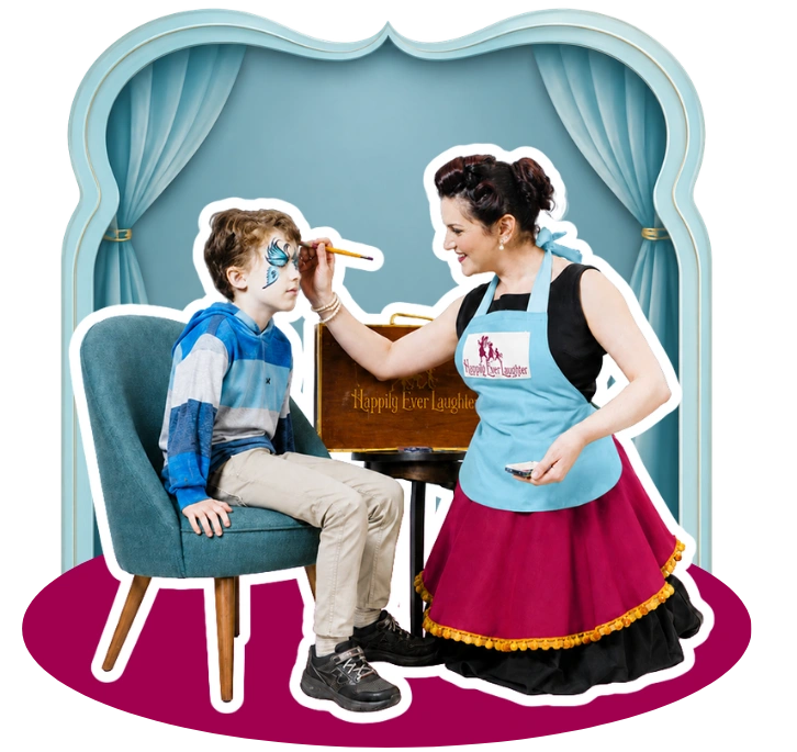 A Happily Ever Laughter face painter painting a butterfly design on a boy seated on a stool in front of a curtain backdrop.