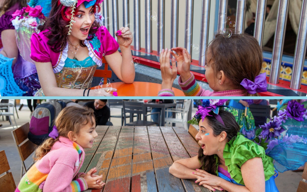 Children gathered around a face painting and play table at an outdoor party.
