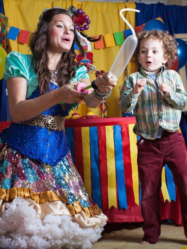 A vibrant children's entertainer from Happily Ever Laughter delights a young guest with balloon twisting magic at a colorful birthday party in San Jose, California. Perfect for parents seeking engaging party entertainment that keeps children smiling and captivated.