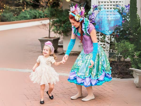 Happily Ever Laughter fairy performer holding hands with a delighted child during an Easter event, adding whimsical charm to a country club celebration.