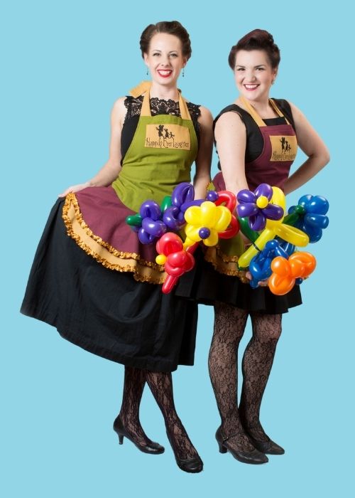 Two Happily Ever Laughter entertainers dressed in charming outfits holding colorful balloon creations, ready to bring fun and creativity to children's parties and special events in California.